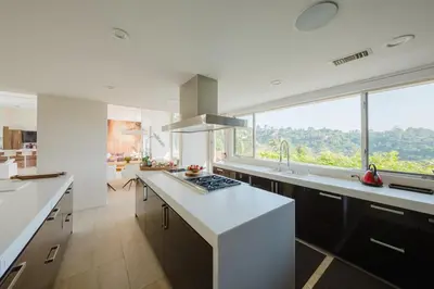a kitchen with white counters and a large window at Zen Estate in Los Angeles
