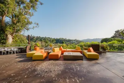 a patio with orange and yellow chairs and a table at Zen Estate in Los Angeles