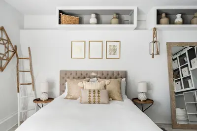 a bedroom with a bed with pillows and shelves at Silver Triangle Oasis with Verdant Backyard in Los Angeles