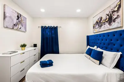 a bedroom with a large bed with a blue headboard at 1 Block to Beach Heaven Chic 2BD in Manhattan Beach