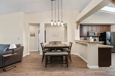 a dining room and kitchen with a table and chairs at Relaxing 4BR 2BA Sleeps 8 Family Friendly in Bakersfield