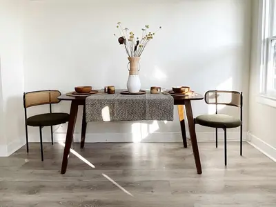 a dining room table with chairs and a vase with flowers at Montecito Heights Hideaway in Los Angeles