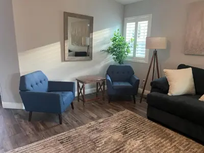 a living room with two blue chairs and a mirror at Cadbury 4BR Outdoor Kitchen Sleeps 8 Peaceful in Bakersfield