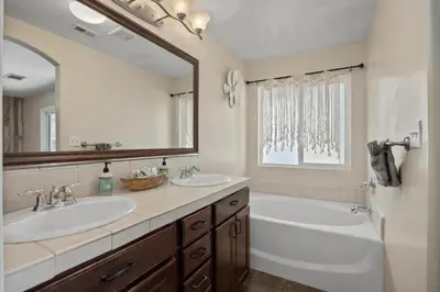 a bathroom with two sinks and a large mirror at 4bdrm 2bath Modern Getaway KING Bed Sleeps 8 in Bakersfield