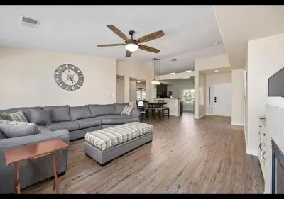 a living room with a couch and a clock on the wall at 4bdrm 2bath Modern Getaway KING Bed Sleeps 8 in Bakersfield