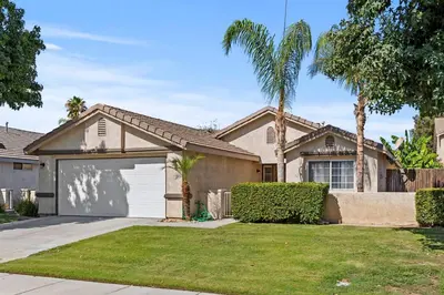 a house with a garage and palm trees at Modern Southwest Escape 2 Master Bedrooms in Bakersfield