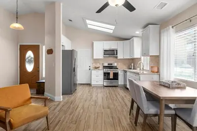 a kitchen with white cabinets and a table and chairs at Modern Southwest Escape 2 Master Bedrooms in Bakersfield