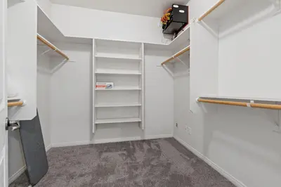 a walk in closet with white walls and white shelves at Windward Bay Executive 3BR Office Home Pool in Bakersfield