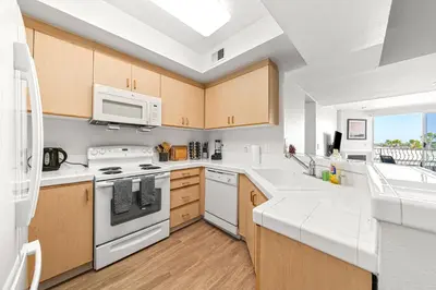 a kitchen with white appliances and a sink at Acacia Waterfront Marina Views Pool Gym Jacuzzi And Sauna in Los Angeles