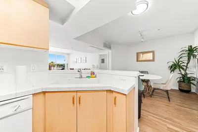 a kitchen with a sink and a dining room at Acacia Waterfront Marina Views Pool Gym Jacuzzi And Sauna in Los Angeles