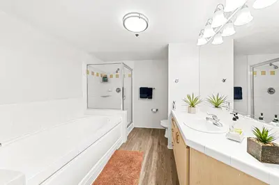 a white bathroom with a tub and a sink at Acacia Waterfront Marina Views Pool Gym Jacuzzi And Sauna in Los Angeles