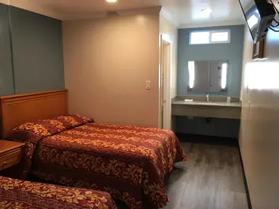 a hotel room with two beds and a sink at Lincoln Park Motel in Los Angeles