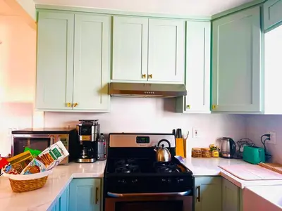 a kitchen with green cabinets and a stove top oven at Cozy Hollywood Cottage - Walk to Larchmont Village in Los Angeles
