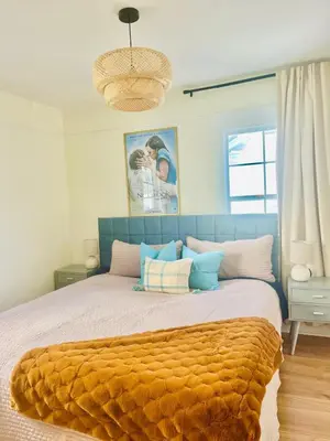 a bedroom with a large bed with an orange blanket at Cozy Hollywood Cottage - Walk to Larchmont Village in Los Angeles