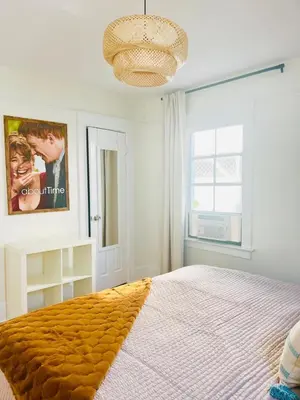 a bedroom with a large bed and a large window at Cozy Hollywood Cottage - Walk to Larchmont Village in Los Angeles