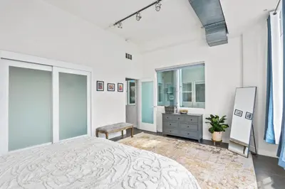 a bedroom with a large bed and a dresser at Stunning DTLA Gem 2 bed with pool, gym and parking in Los Angeles