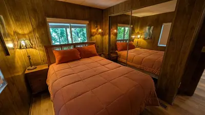 a bedroom with two beds and a large mirror at Peaceful Pines Place, a cozy mountain hideaway wAC
