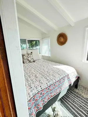a bedroom with a bed and two windows at Serene & beautiful bohemian hilltop retreat in Glendale