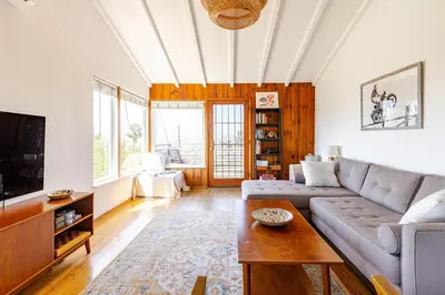 a living room with a couch and a tv at Serene & beautiful bohemian hilltop retreat in Glendale