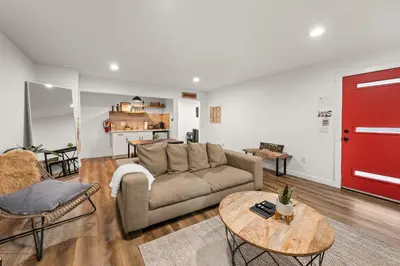 a living room with a couch and a red door at Cozy Knight Cabin - AC! Walk to Lake and Village in Big Bear Lake