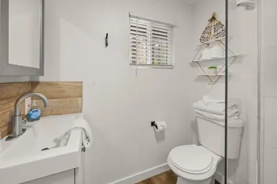 a white bathroom with a toilet and a sink at Cozy Knight Cabin - AC! Walk to Lake and Village in Big Bear Lake