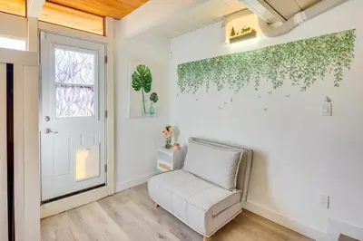 a living room with a chair and a window at Stroll to Beach and Pepperdine Airy Malibu Studio in Malibu