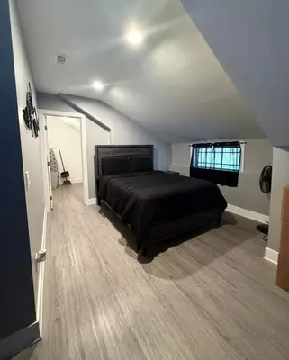 a bedroom with a black bed in a attic at The Jazz Room - Executive Suite Downtown Riverside in Riverside