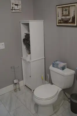 a white bathroom with a toilet and a cabinet at The Jazz Room - Executive Suite Downtown Riverside in Riverside