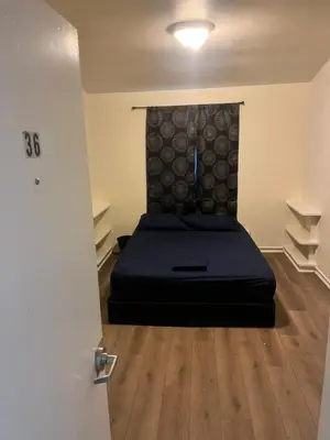 a bedroom with a bed in a room with wooden floors at Van Nuys Vibe in Van Nuys County Court Heliport