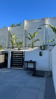 a patio with a bench and a fence with plants at Wellness Villa Resort in Abbeyville