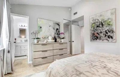a white bedroom with a dresser and a mirror at Wellness Villa Resort in Abbeyville