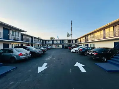 a parking lot with cars parked in front of a building at Del Aire Inn LAX in Inglewood