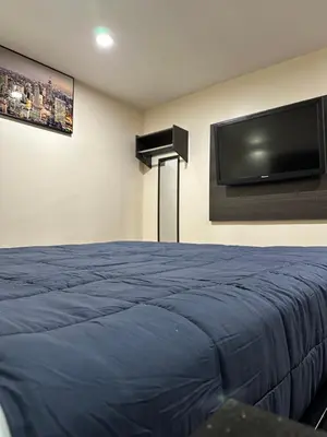 a bedroom with a bed and a flat screen tv at Del Aire Inn LAX in Inglewood