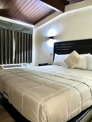 a large white bed in a bedroom with a window at Del Aire Inn LAX in Inglewood