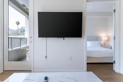 a living room with a flat screen tv on a wall at Luxury 2 Bedroom 2 Bathroom Residence With Fitness and Outdoor Pool in Los Angeles