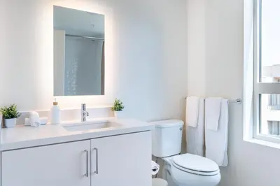 a white bathroom with a toilet and a sink at Luxury 2 Bedroom 2 Bathroom Residence With Fitness and Outdoor Pool in Los Angeles