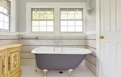 a bath tub in a white bathroom with windows at Hollywood Deluxe Homestay in Los Angeles