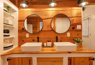 two sinks in a bathroom with two mirrors at Little Wolf Lodge Modern Cabin at Lake Gregory in Crestline