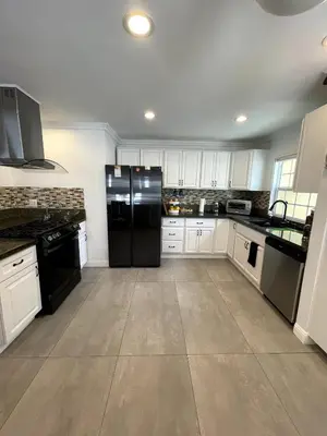 a kitchen with a black refrigerator and white cabinets at House in Redondo Beach 2 bedroom 1 bath in Redondo Beach
