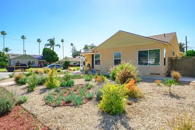 a garden in front of a house with plants at Modern New 3B Home Fully Stocked & Cozy & Sunlight