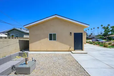 a house with a blue door in a driveway at Cozy Modern Home w Full Kitchen & Parking