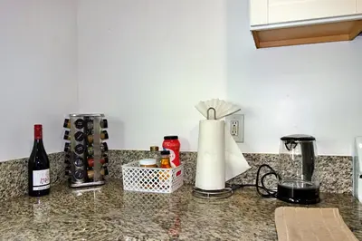 a kitchen counter with bottles of wine and a counter top at Casa Mid City - Centrally Located 1BR Getaway with Private Yard in Los Angeles