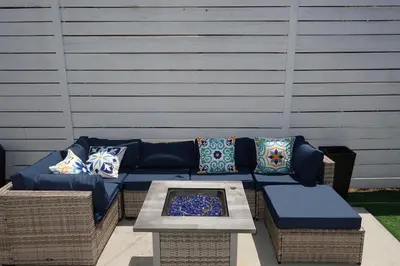 a blue couch with pillows on a patio at Casa Mid City - Centrally Located 1BR Getaway with Private Yard in Los Angeles