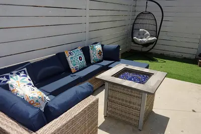 a blue couch sitting on a patio with a table at Casa Mid City - Centrally Located 1BR Getaway with Private Yard in Los Angeles