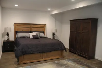 a bedroom with a large bed and a wooden cabinet at Champagne Retreat in Upland