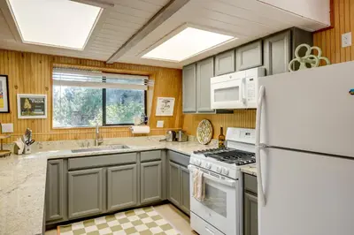 a kitchen with gray cabinets and a white refrigerator at Walk to Village Cozy Cabin in Pine Mountain Club! in Pine Mountain Club