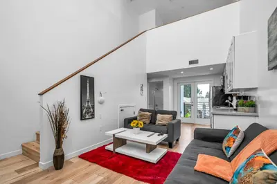 a living room with a couch and a table at Chic 1 Bedroom Loft with Balcony Hollywood Sign View Free Gated Parking Full Kitchen in Los Angeles