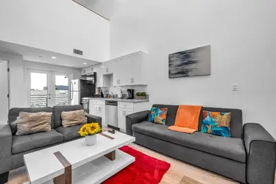 a living room with two couches and a table at Chic 1 Bedroom Loft with Balcony Hollywood Sign View Free Gated Parking Full Kitchen in Los Angeles