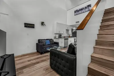 a living room with a staircase and a couch at Stylish 1 Bedroom Loft in Hollywood Balcony Free Gated Parking In Unit Laundry in Los Angeles