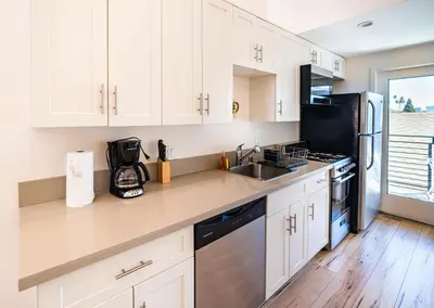 a kitchen with white cabinets and a sink at Koreatown Hollywood Urban Oasis 1 Bedroom Loft with Private Parking and Balcony in Los Angeles